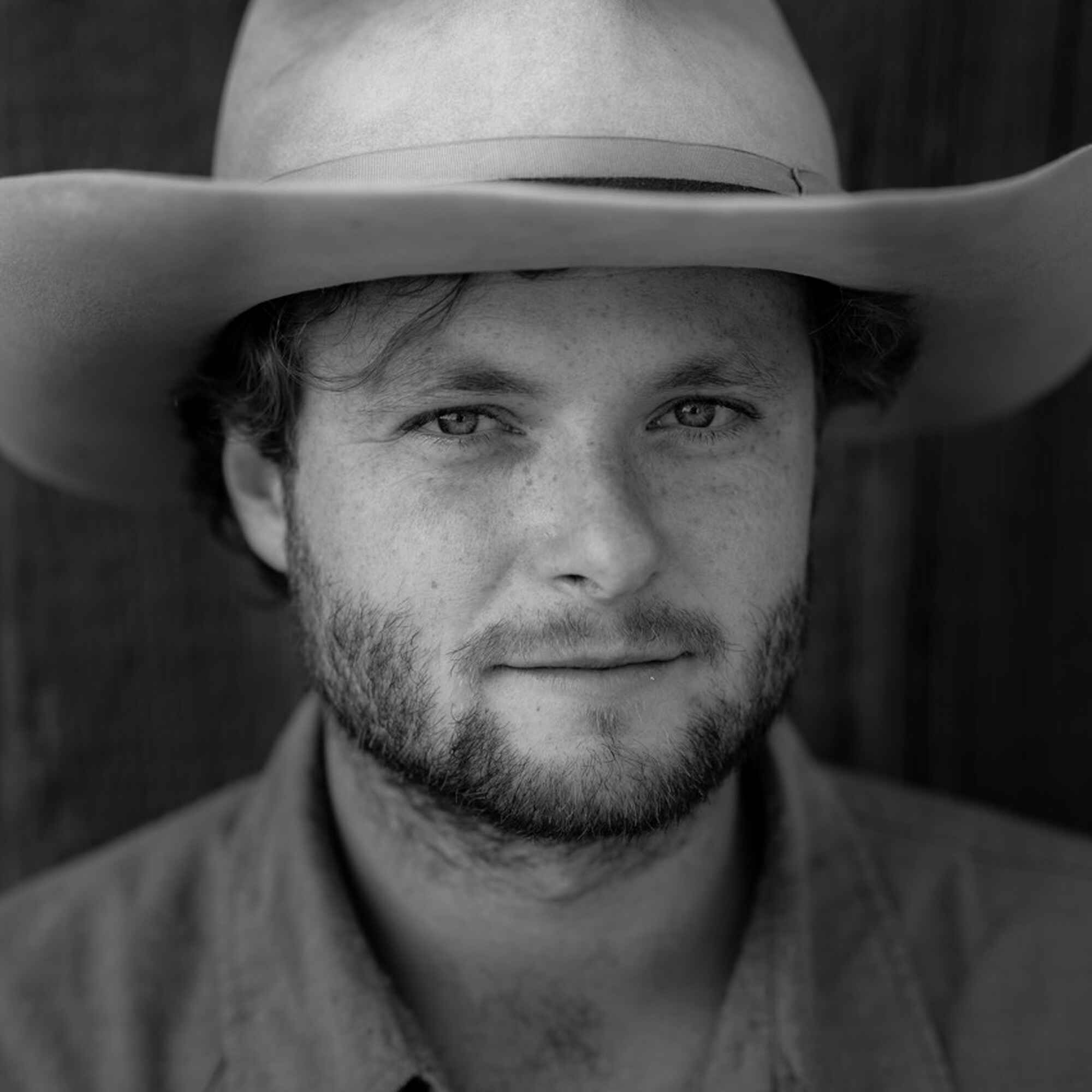 Liam Pickhardt, a man wearing a cowboy hat and collared shirt, in a black and white portrait