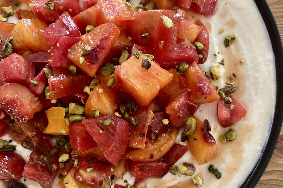 Caramelized peach and heirloom tomato salad served on whipped feta, garnished with pistachios