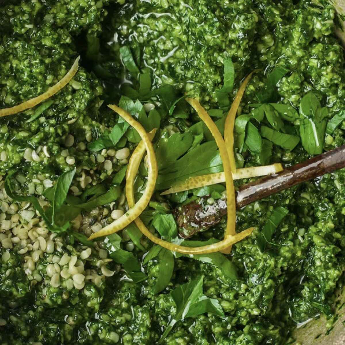 Hemp pesto with fresh basil and lemon zest in a wooden bowl