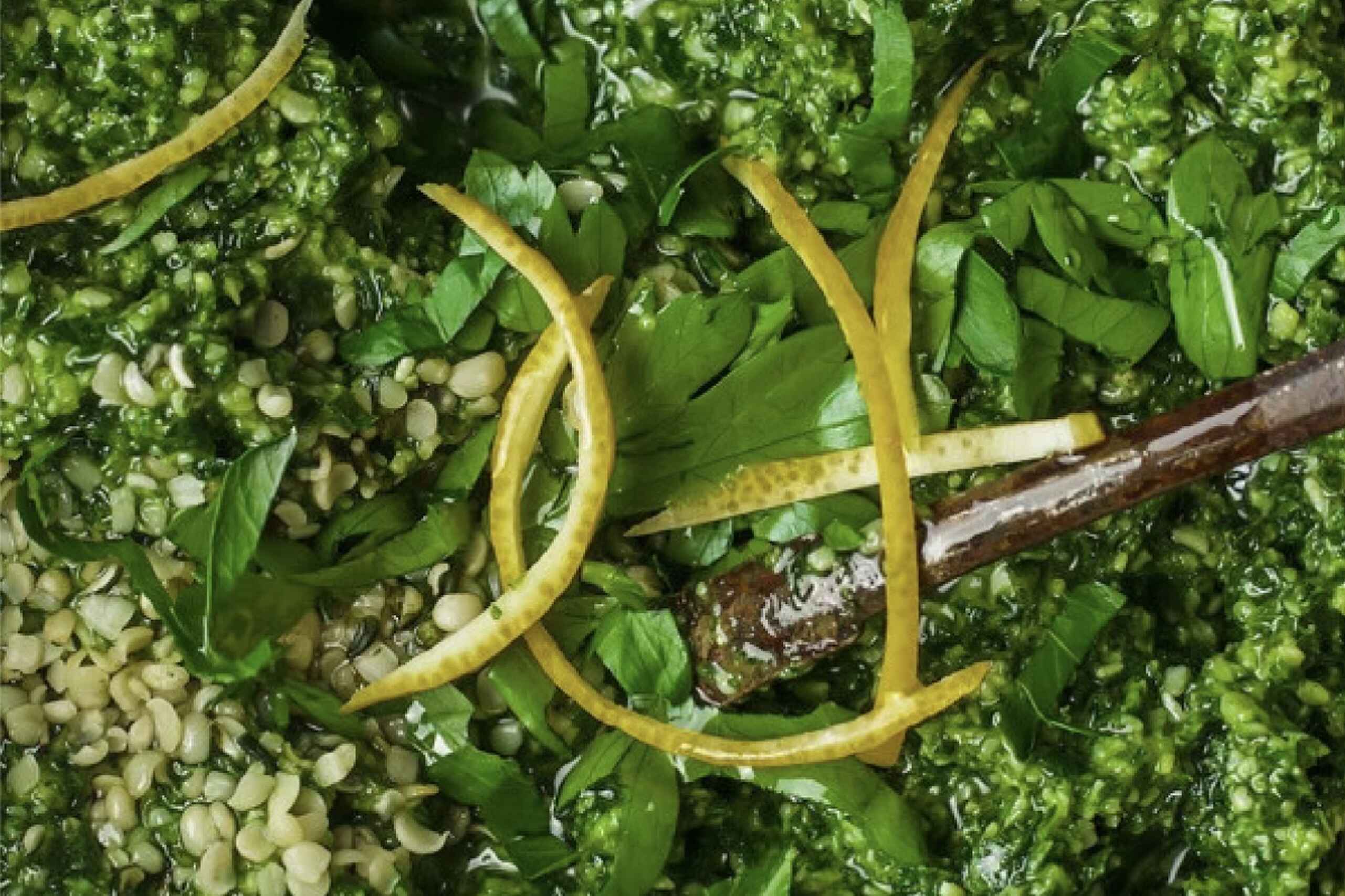Hemp pesto with fresh basil and lemon zest in a wooden bowl