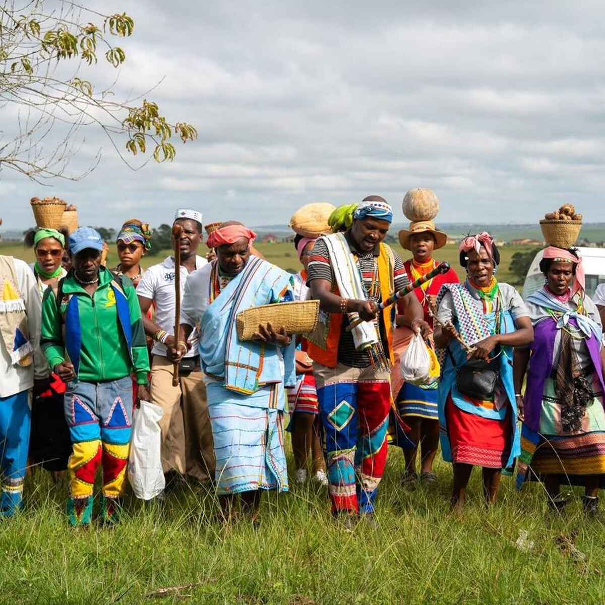 Group of farmers in traditional and colorful clothing standing together in a rural field