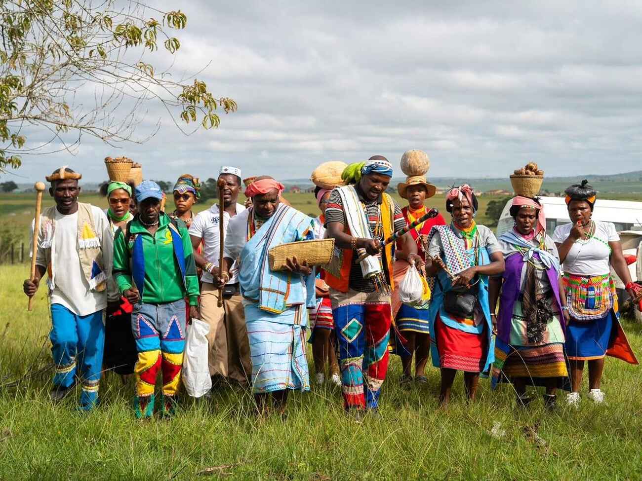 Group of farmers in traditional and colorful clothing standing together in a rural field