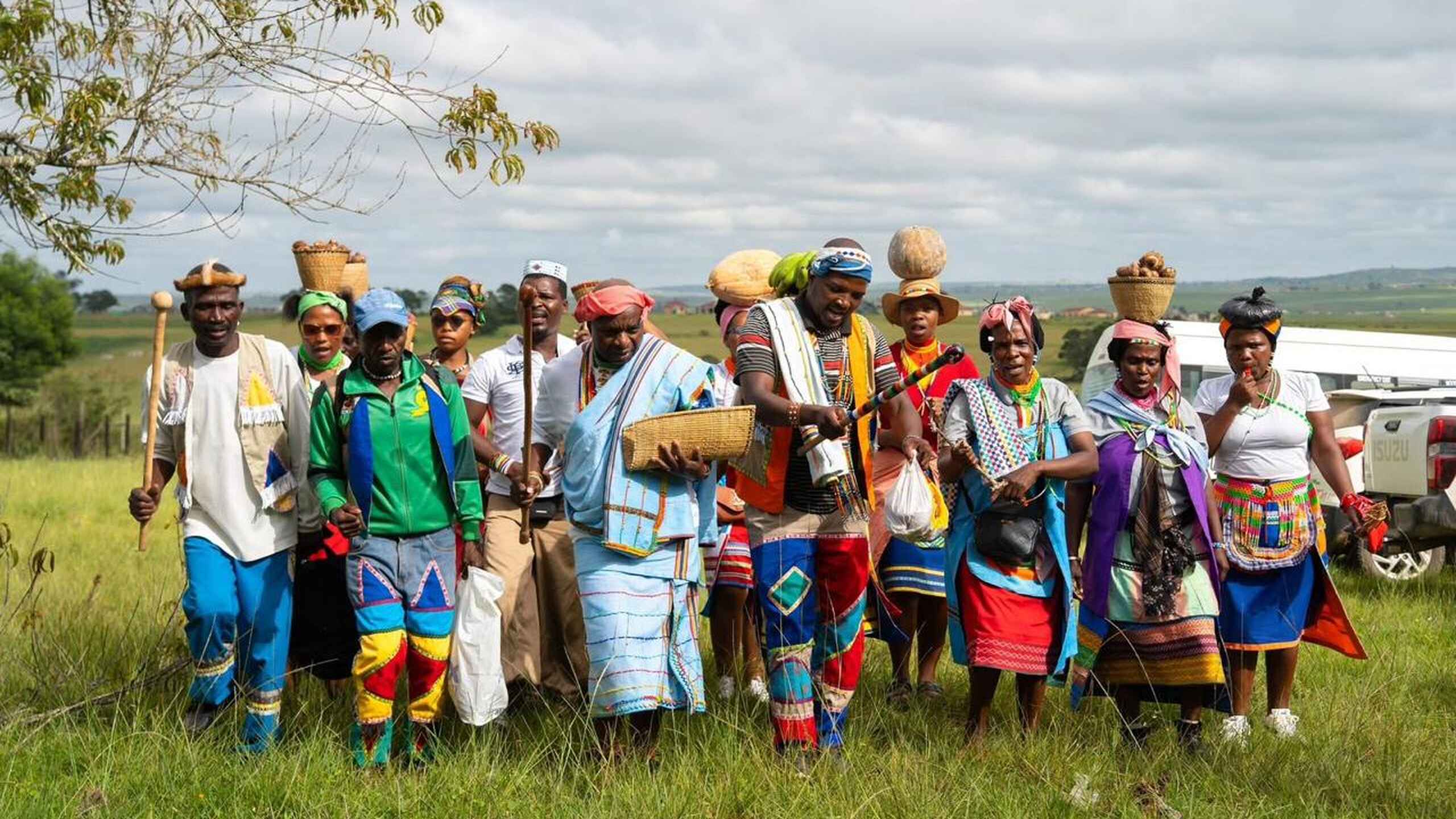 Group of farmers in traditional and colorful clothing standing together in a rural field