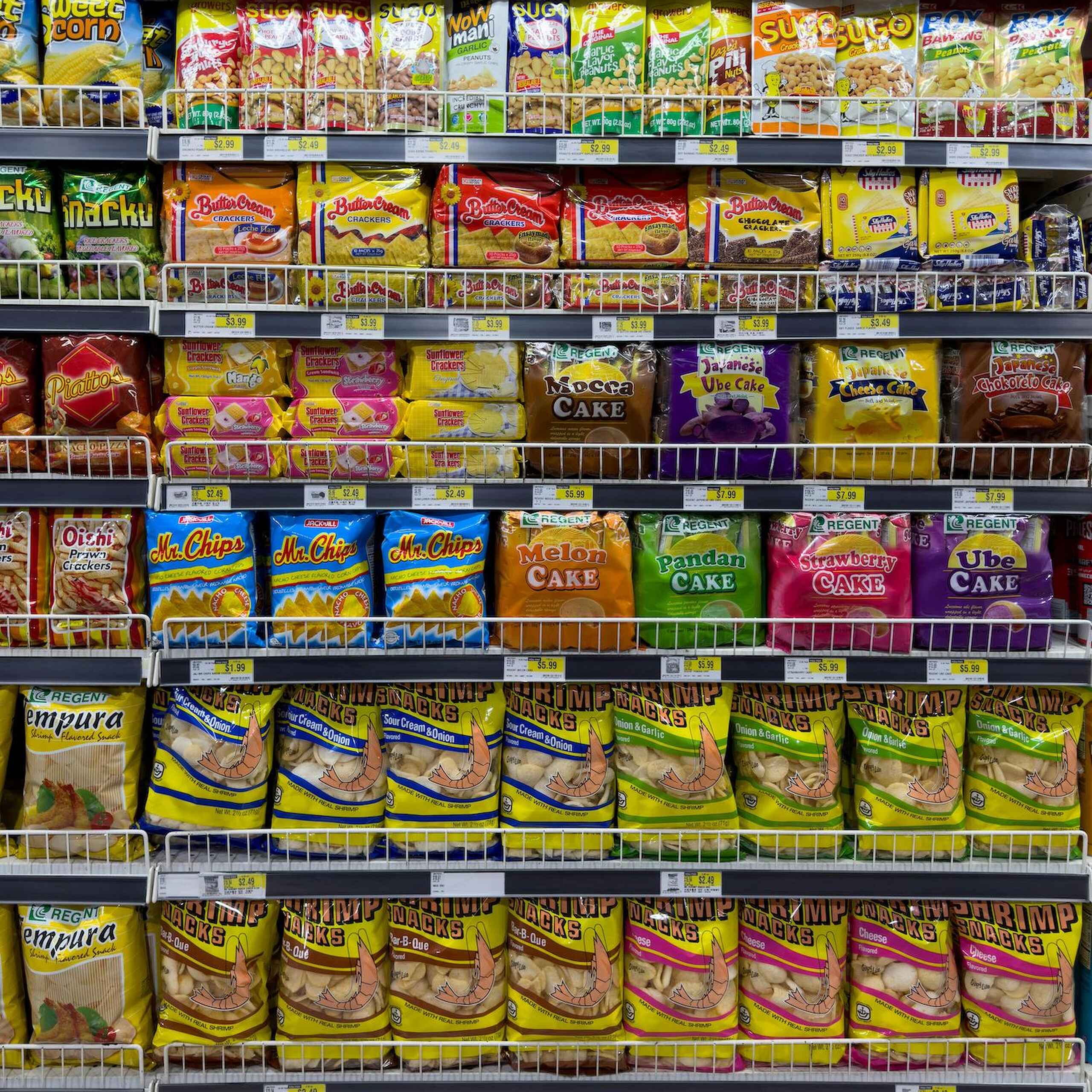 Stock room shelves displaying packaged Asian snack foods and instant noodles in various brands and flavors