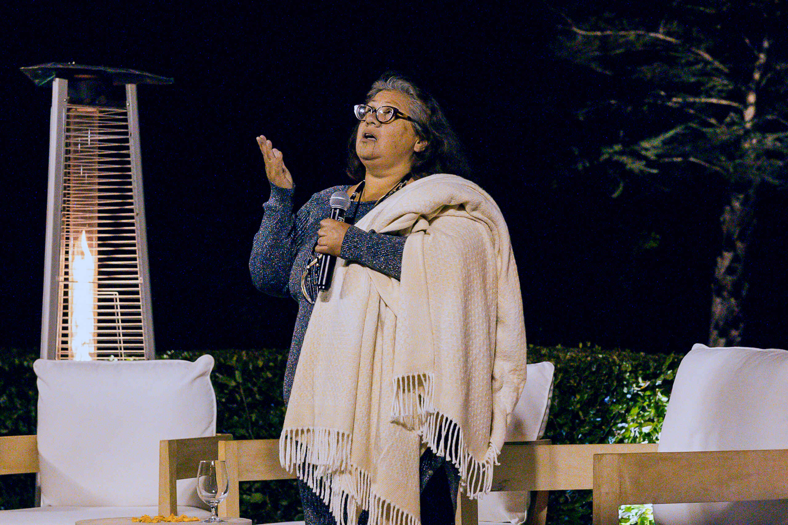 Mia Mar&iacute;a L&oacute;pez speaking at an outdoor evening event about indigenous perspectives and sustainable agriculture