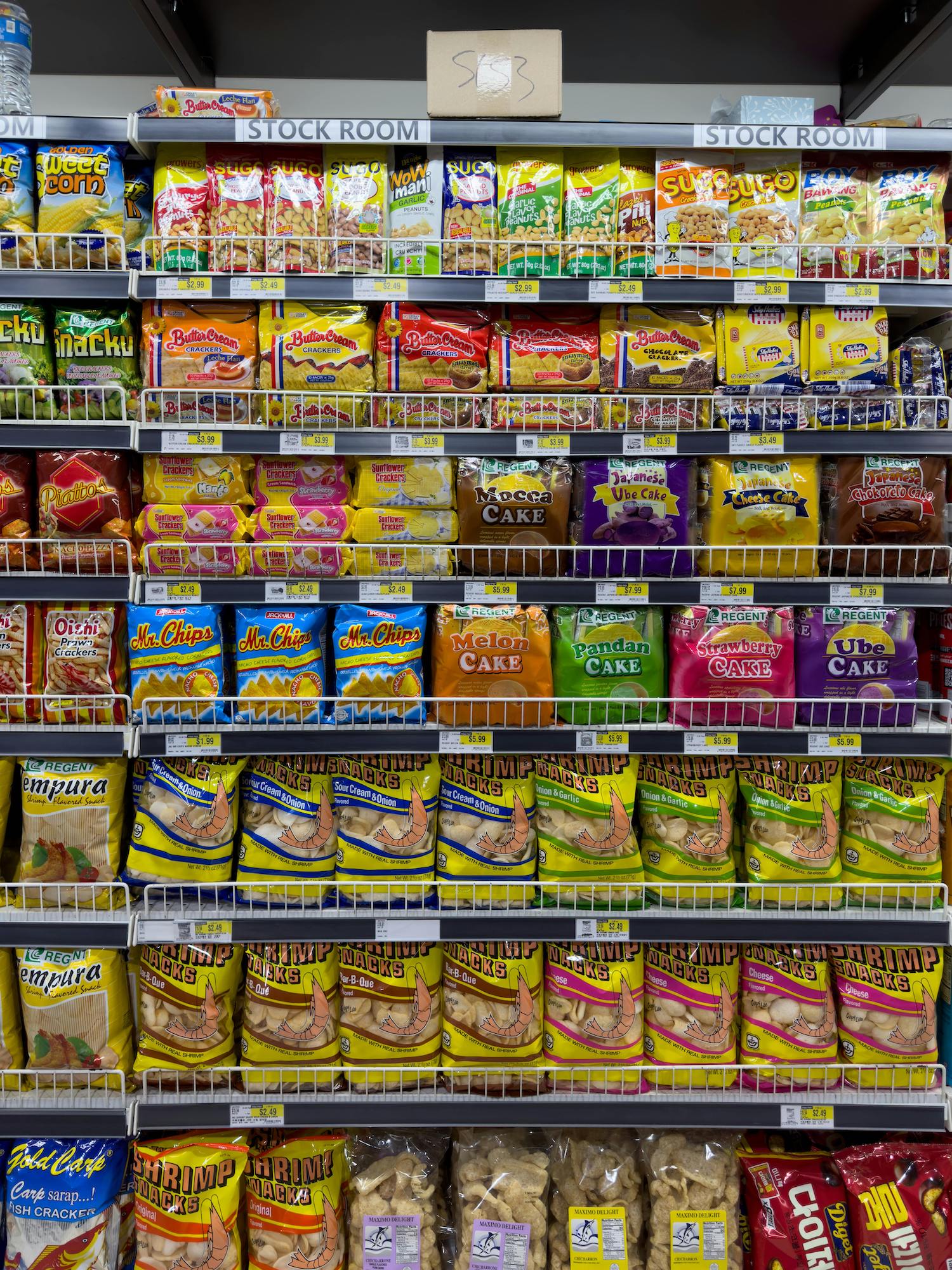 Stock room shelf displaying packaged ultra-processed snack foods and cakes from various brands