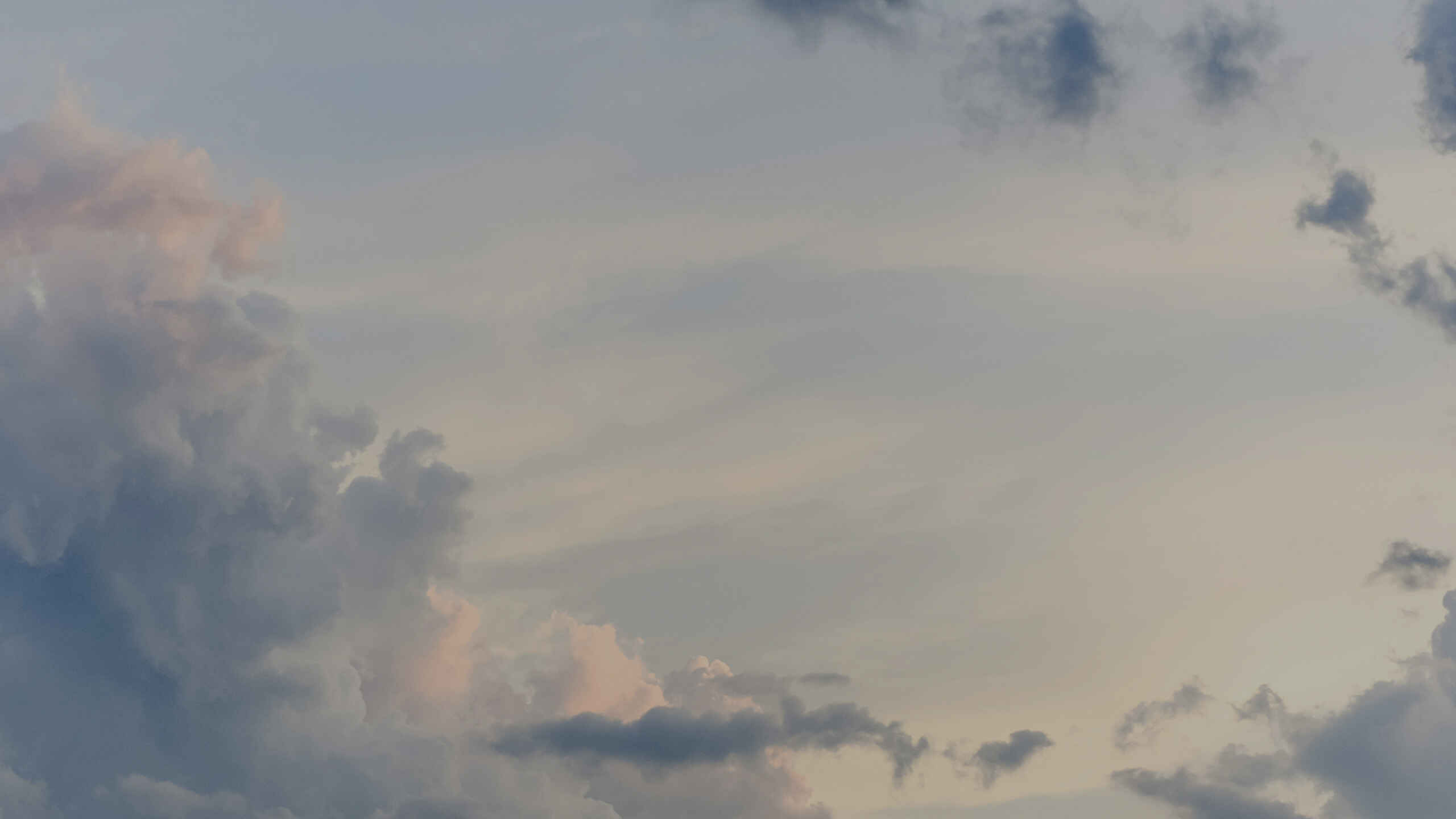 Wide open sky filled with gentle storm clouds at dusk