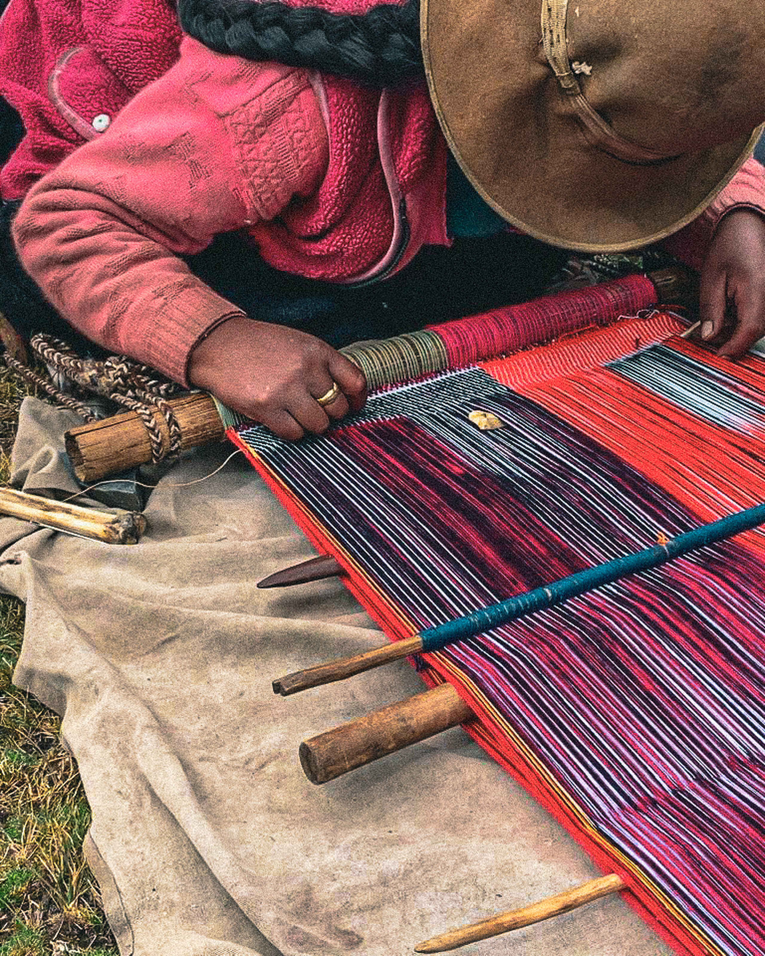 Artisan weaving traditional textiles with colorful threads and hand tools