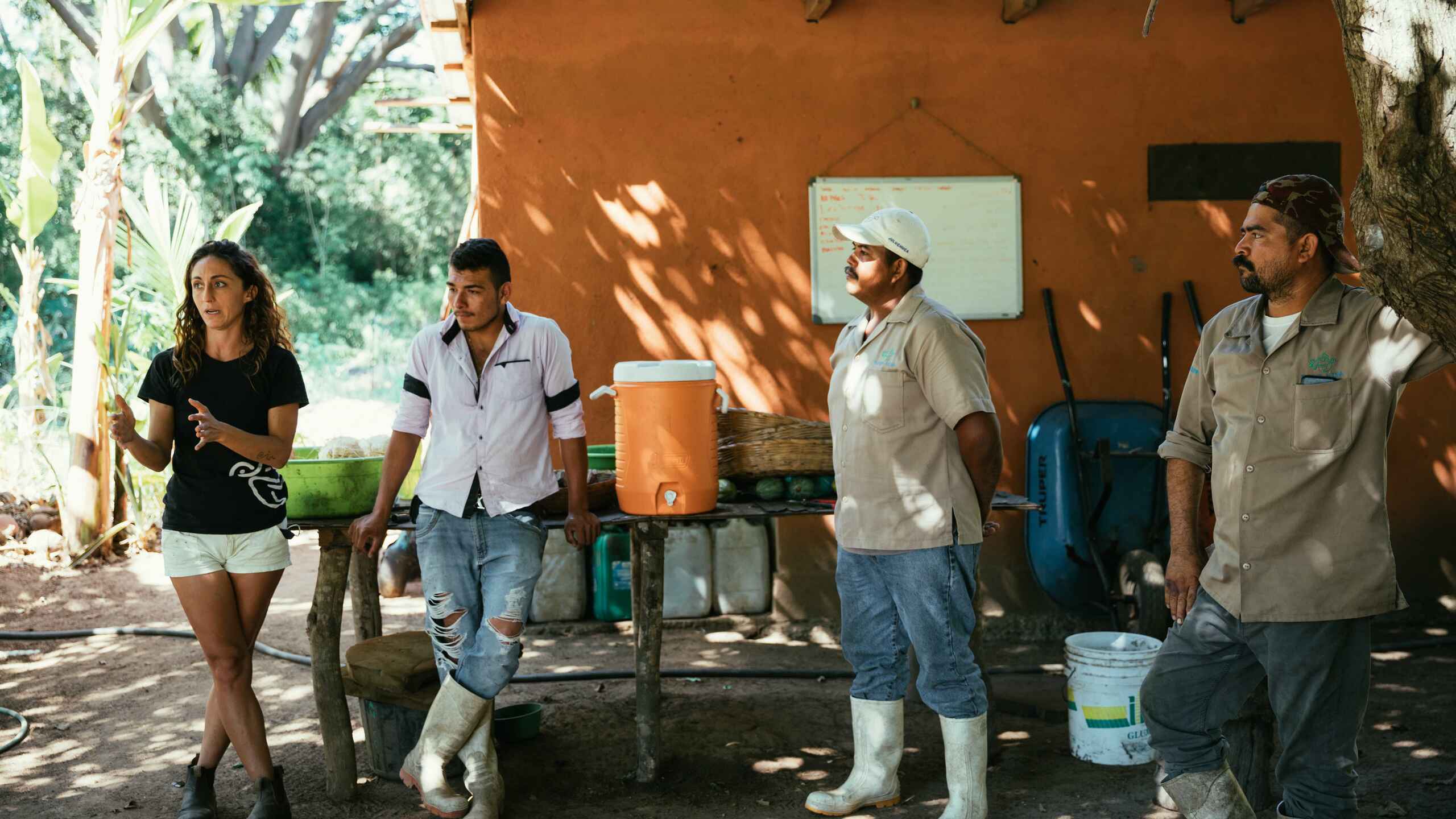 Amanda Harris leads a farm tour discussing sustainable agriculture practices with team members at a rural facility