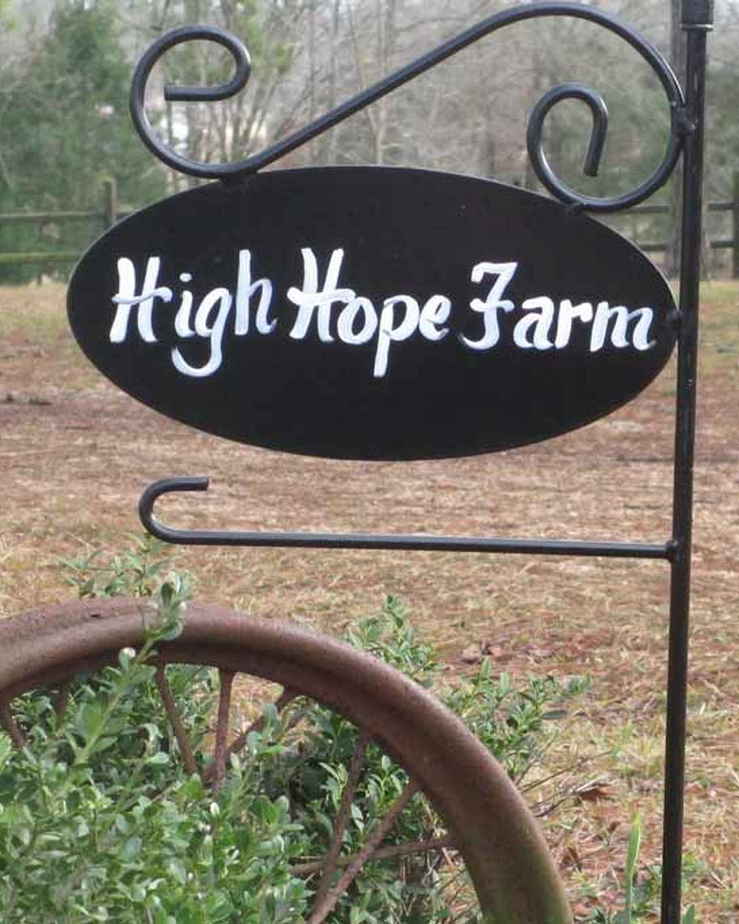 High Hope Farm entrance sign with decorative iron bracket and rustic horseshoe planter