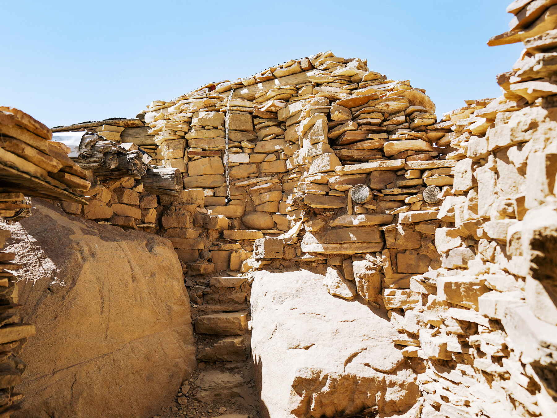 Stacked stone walls forming traditional Hopi structures in a desert landscape