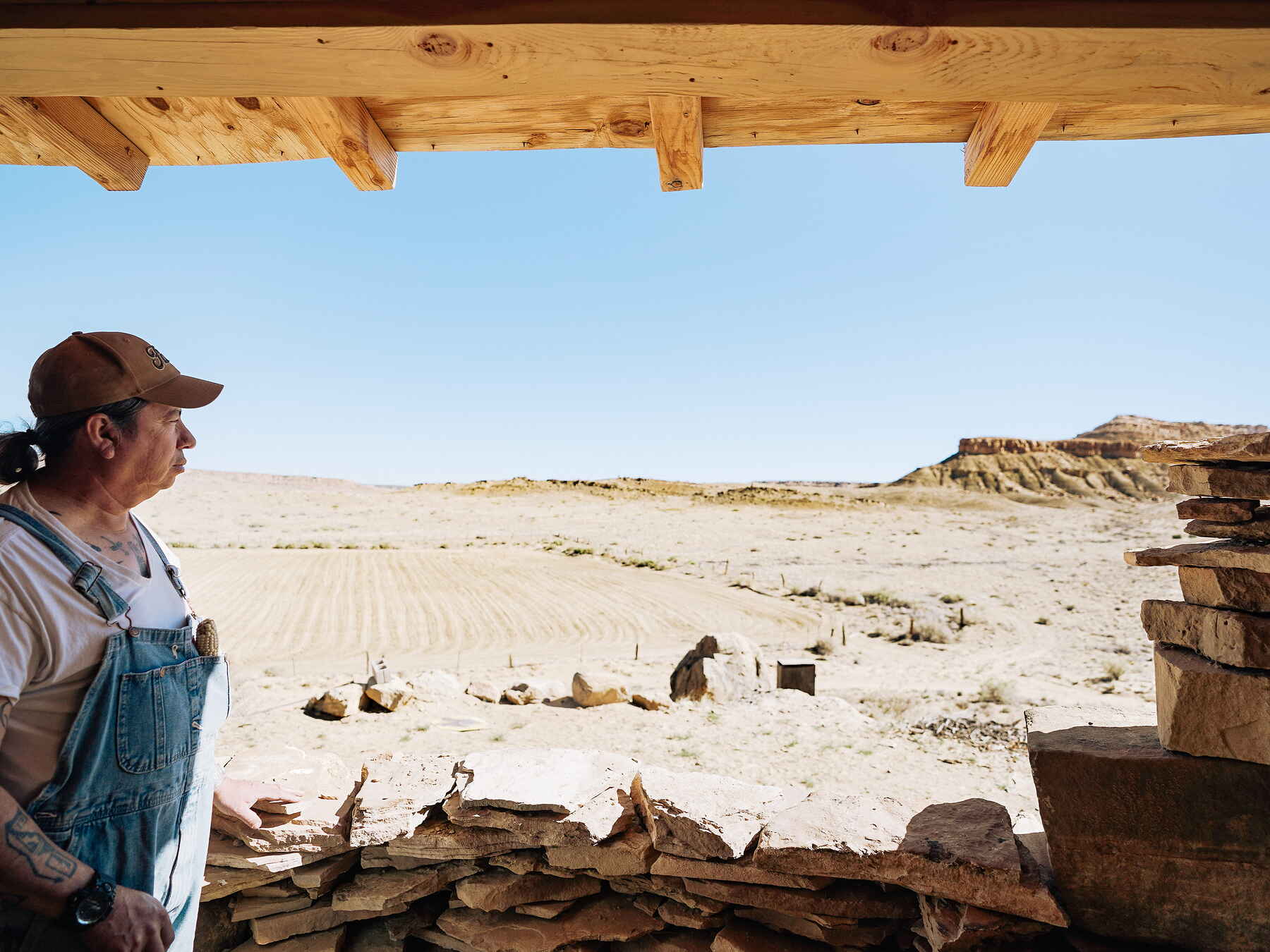 Dr. Michael Kotutwa Johnson surveys the arid landscape from a traditional Hopi structure in Arizona