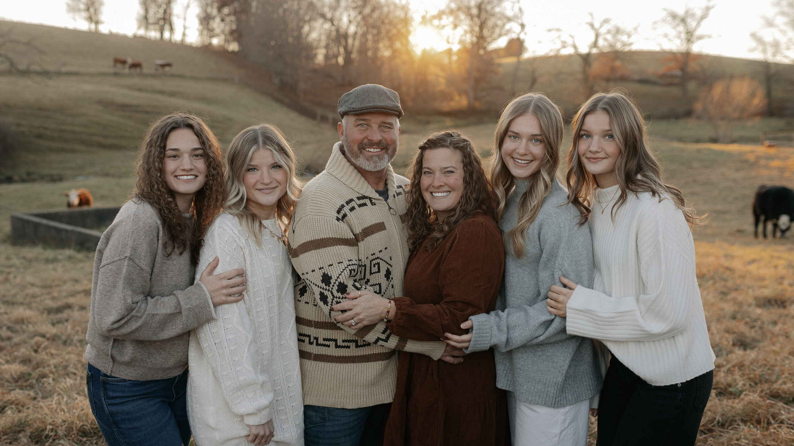 Volenec family standing together in a pasture at sunset on their farm