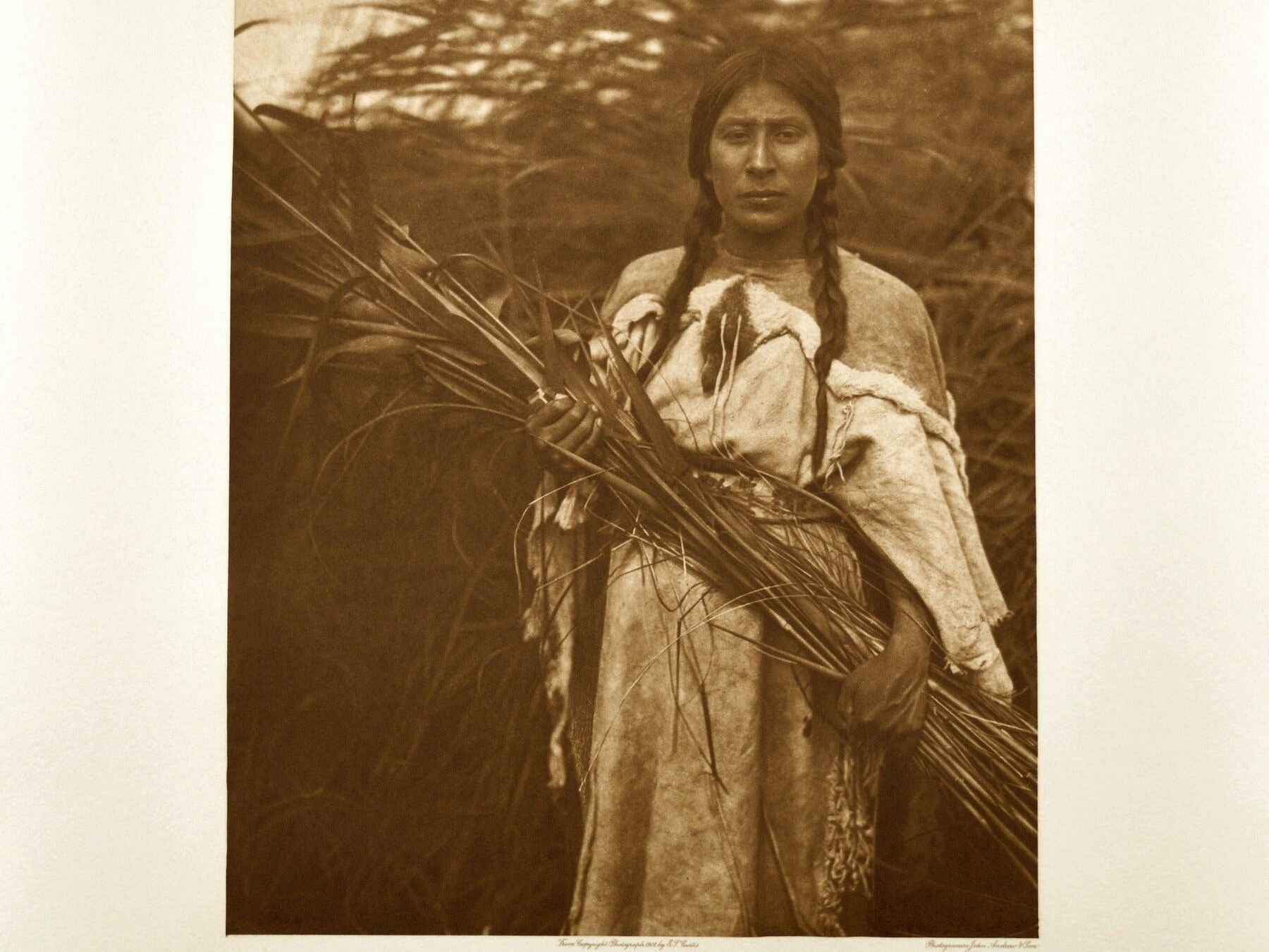 Arikara woman holding bundled rushes, early 20th century photograph by Edward Curtis
