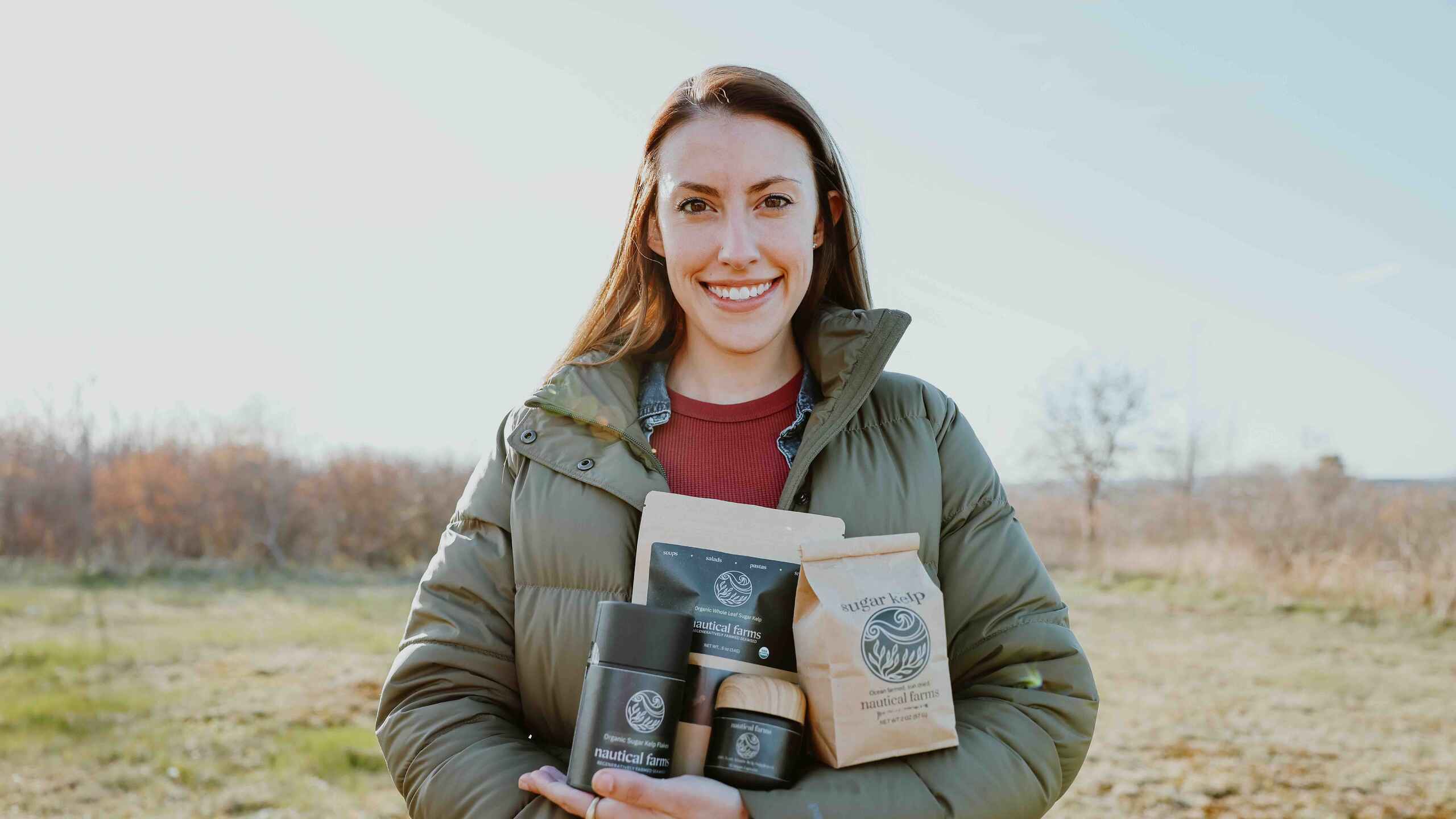 Woman holding Nautical Farms products in a rural field