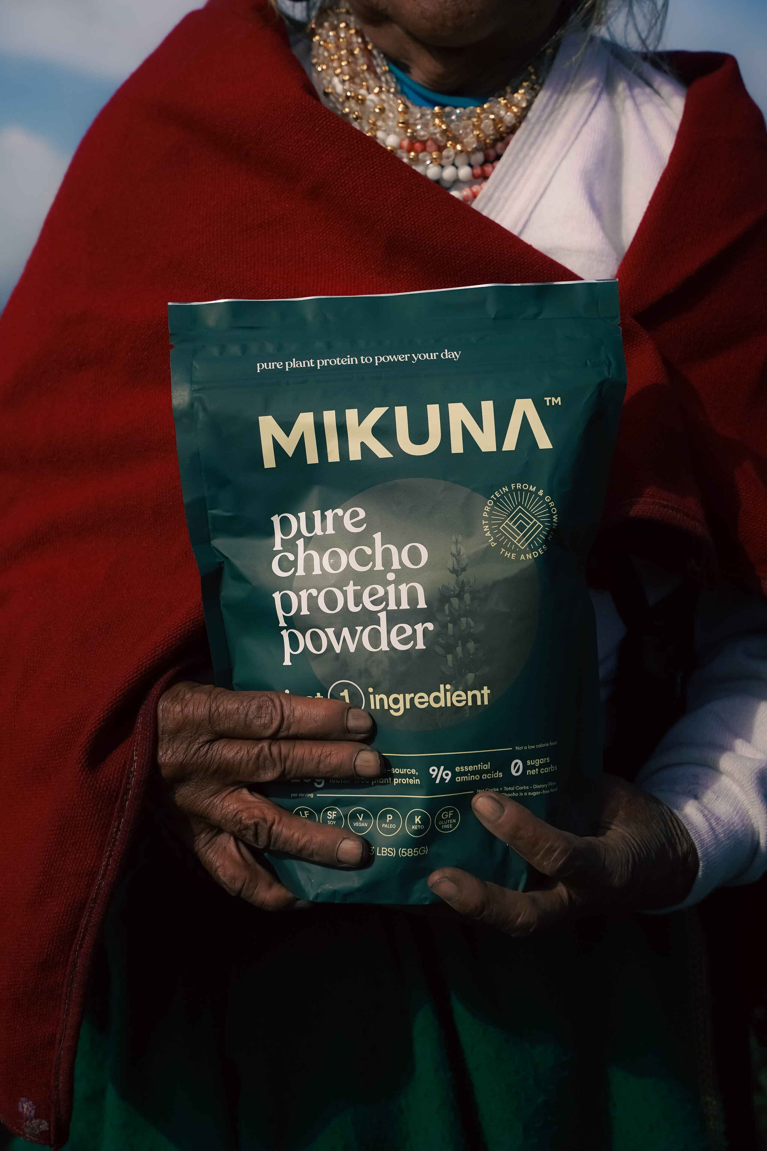 Persona sosteniendo un paquete de polvo de prote&iacute;na de chocho puro Mikuna, un producto de prote&iacute;na a base de plantas de los Andes ecuatorianos