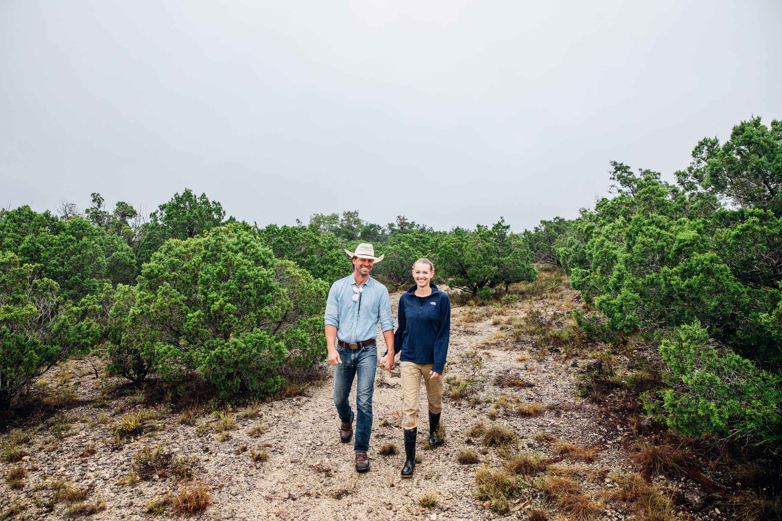 Tina y Orion Weldon caminando a trav&eacute;s de su rancho regenerativo rodeado de matorrales nativos