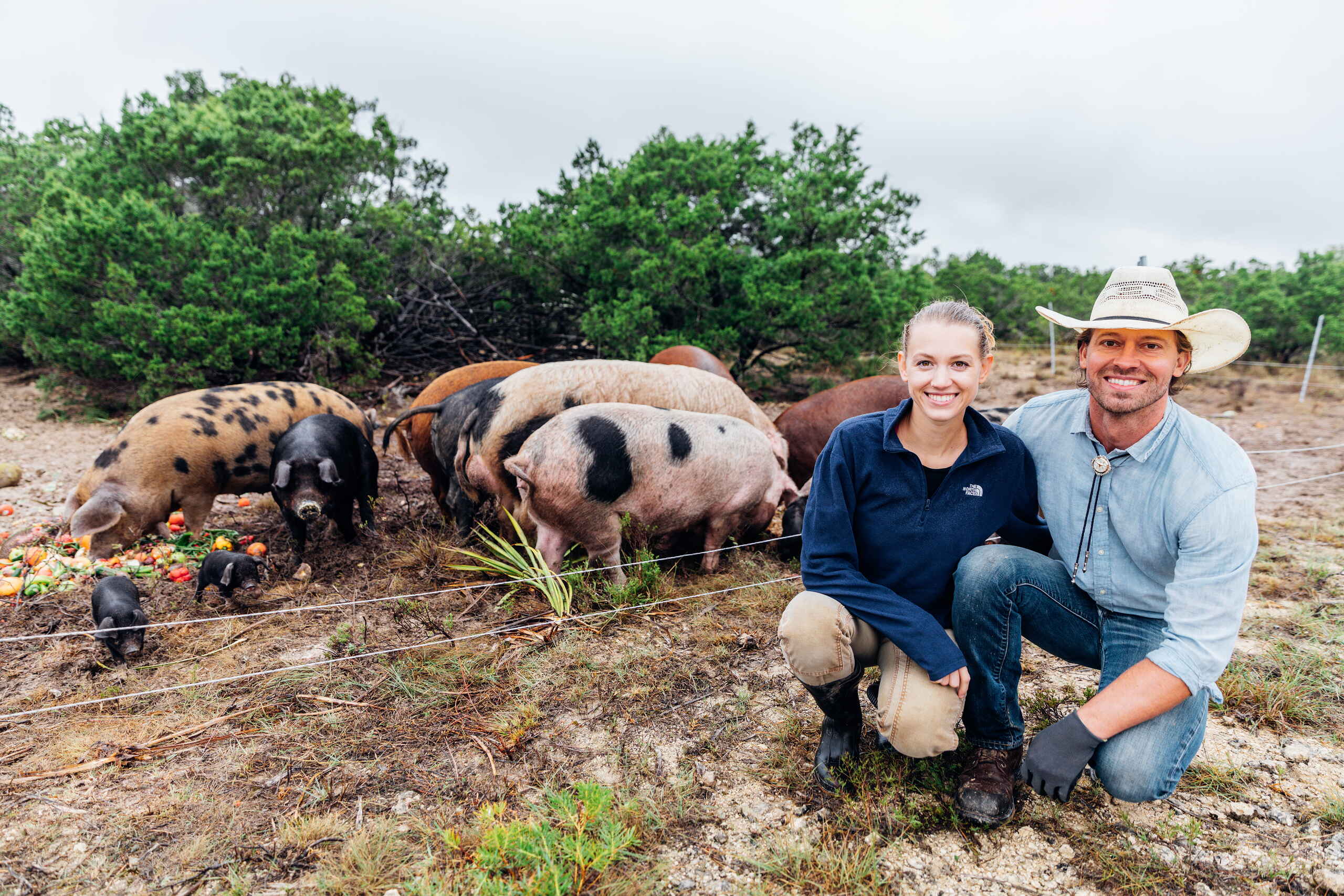 Tina y Orion Weldon posan con sus cerdos de raza heritage en su rancho regenerativo