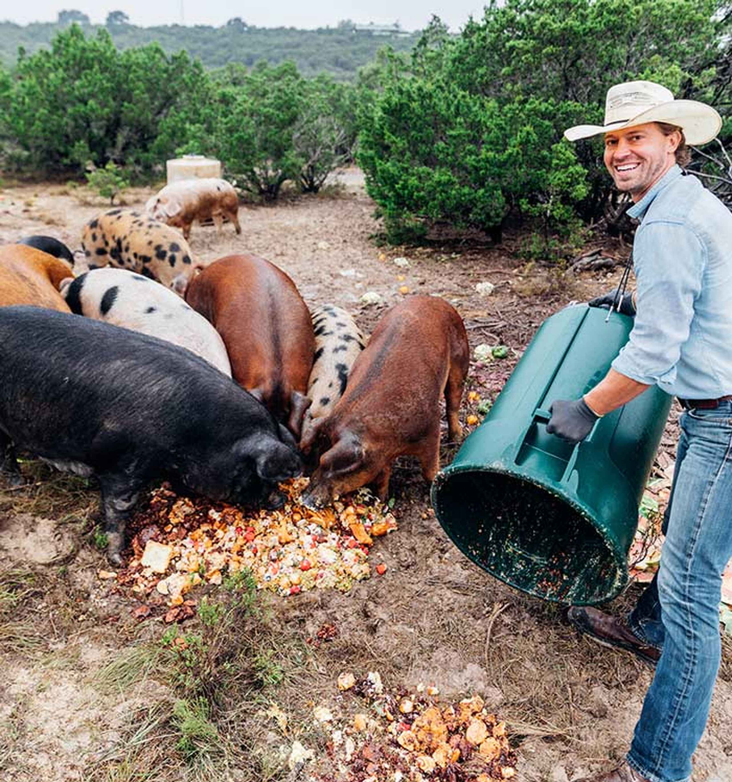 Farmer Orion Weldon feeds a group of heritage breed pigs on his ranch in Texas