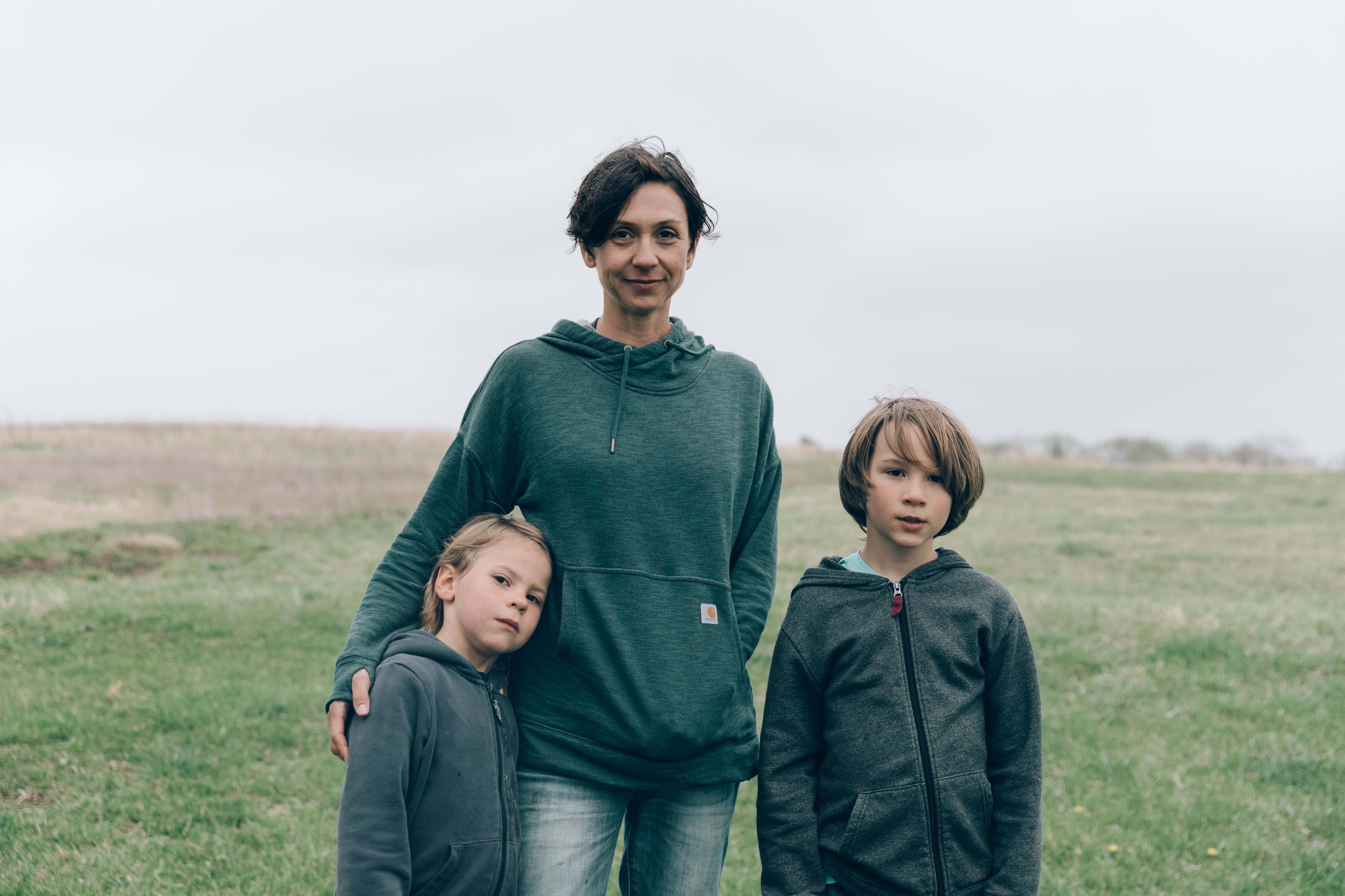 Woman and two children standing together in a farm field